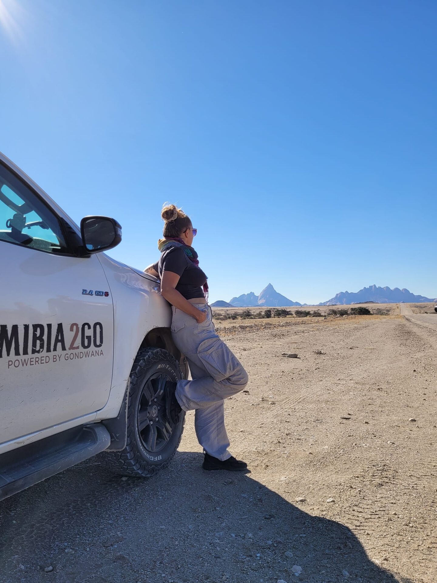 Na zdjęciu Alicja Żak opiera się o samochód, stojący na pustyni